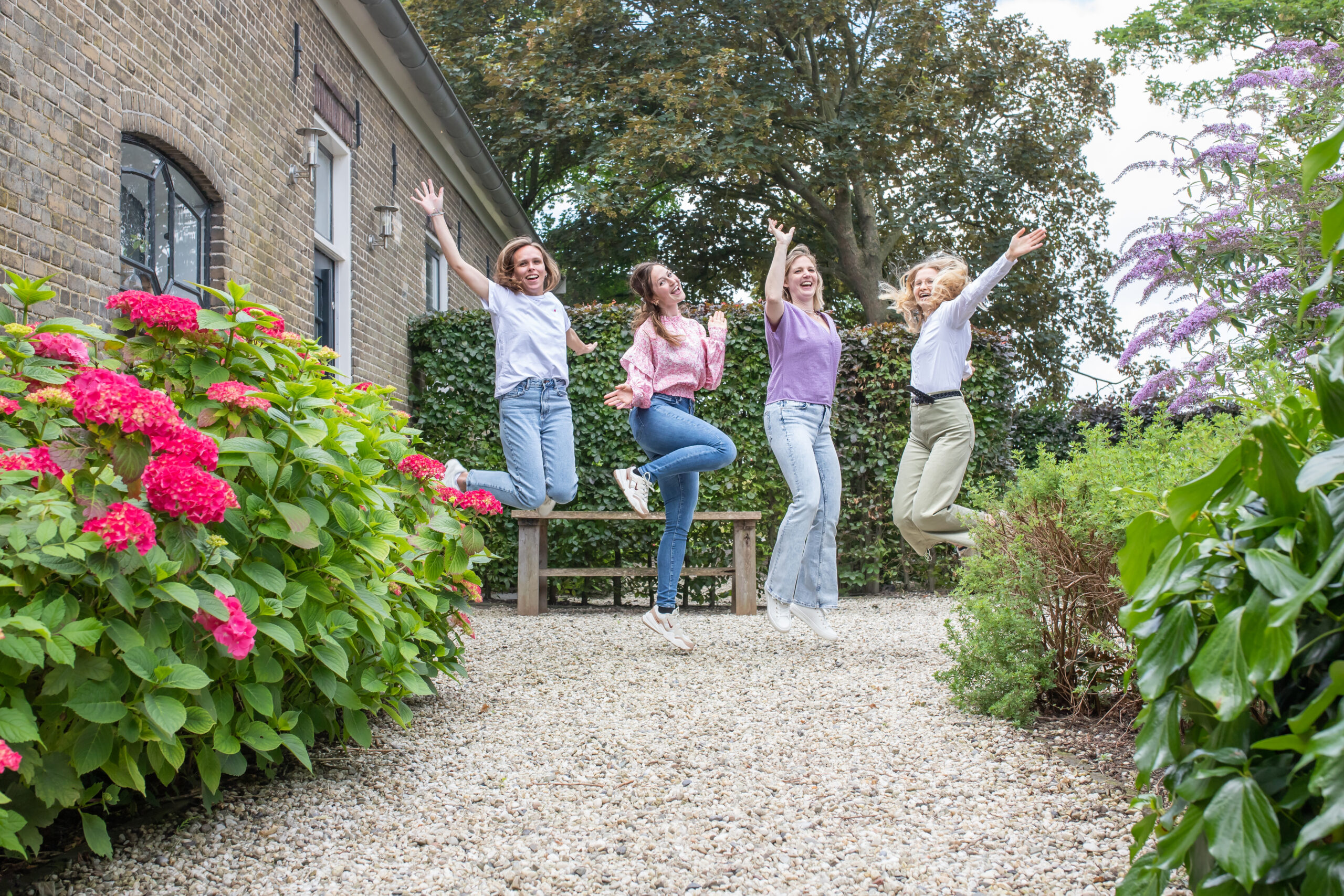 Groepsfoto springend in tuin